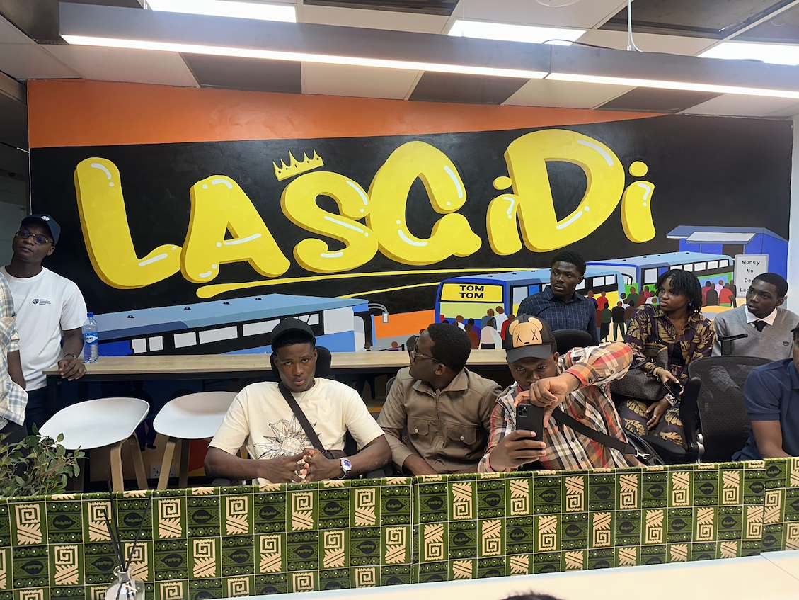 Des étudiants d'Epitech prennent un selfie devant un miroir géant sur lequel est inscrit en gras « LasGiDi », symbole de Lagos.